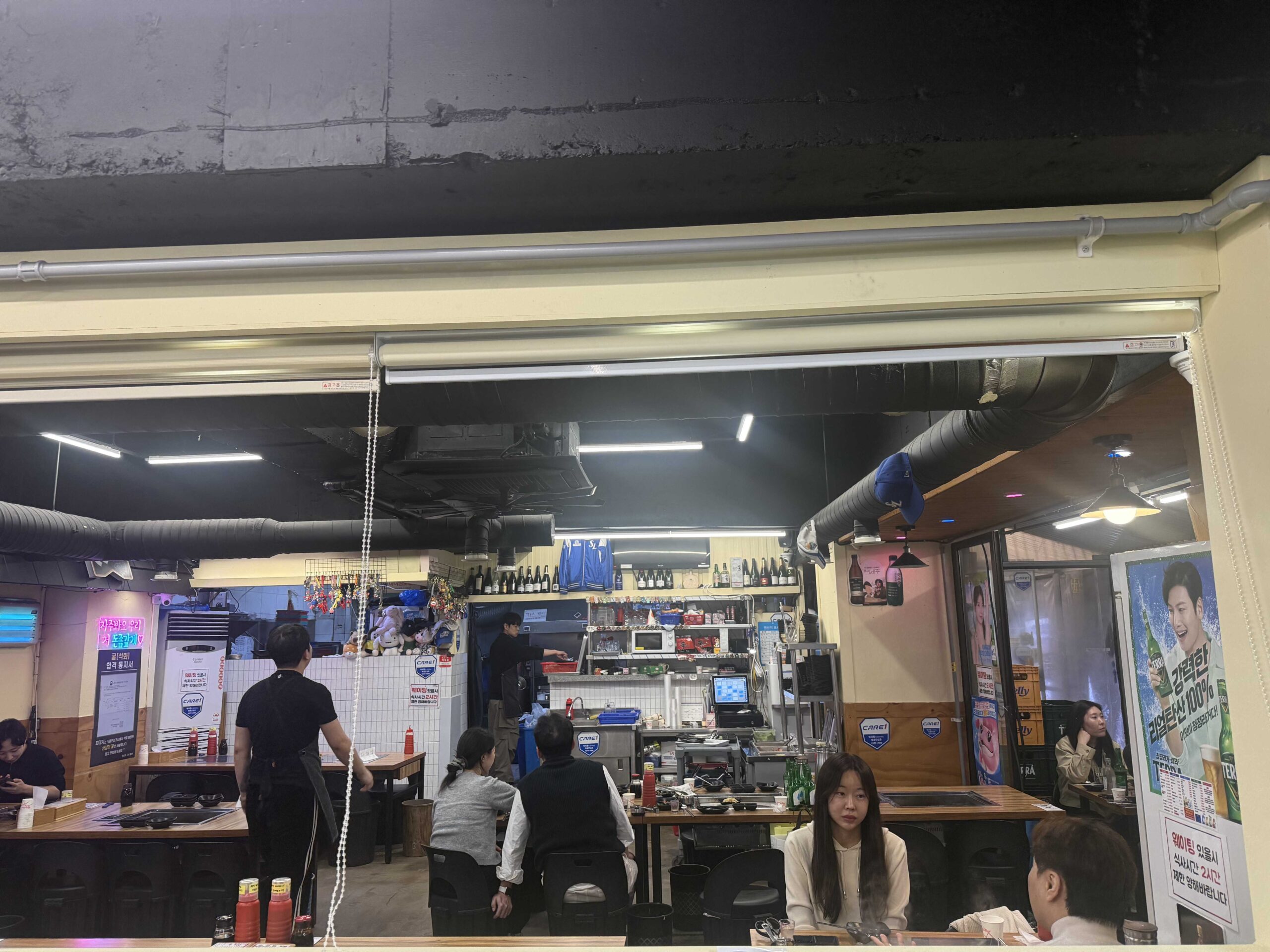 Jjimagi Jamsil Bangi restaurant interior showing open kitchen and busy dining area