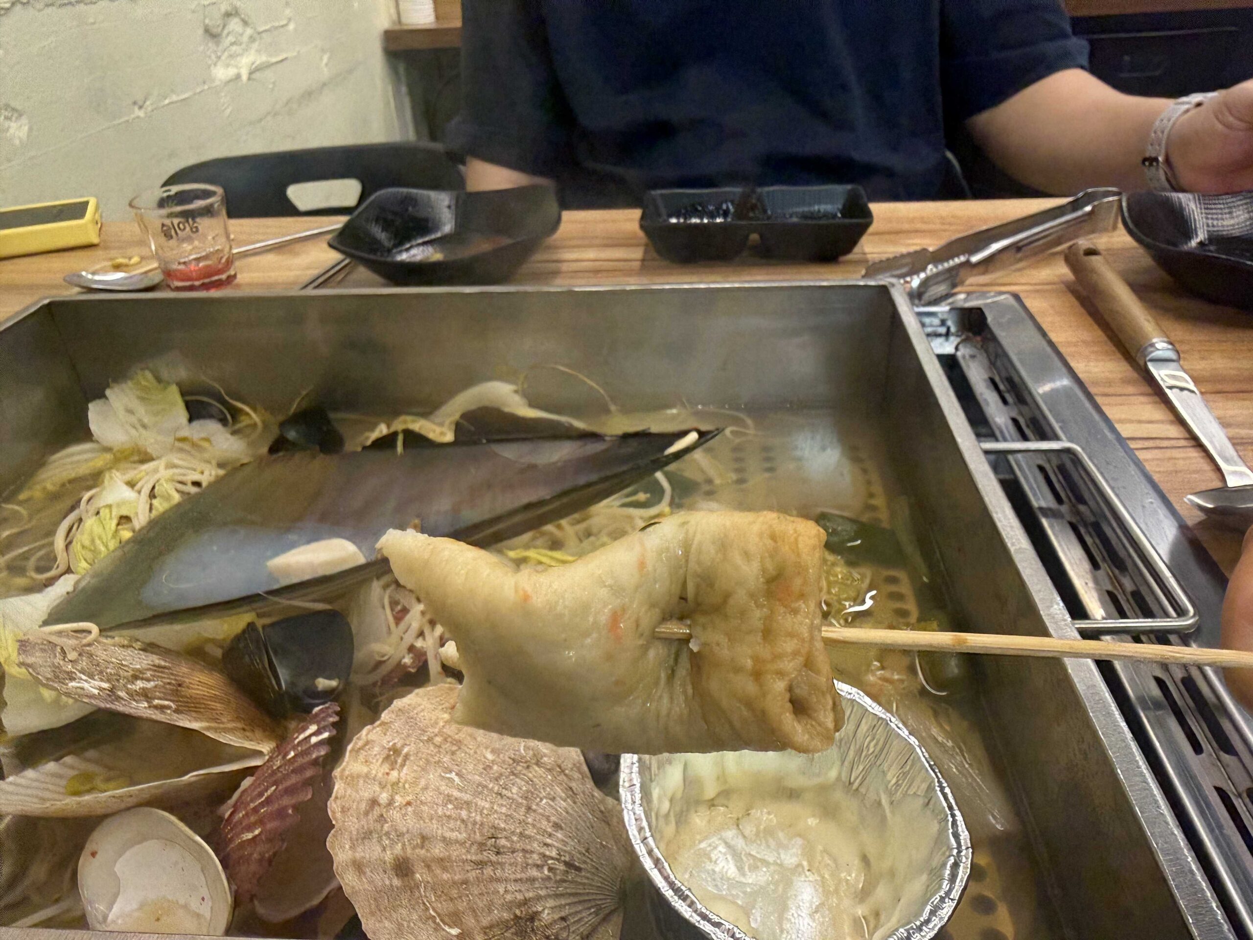 Jjimagi Jamsil Bangi seafood steamer with fish cake skewer and razor clam in the center