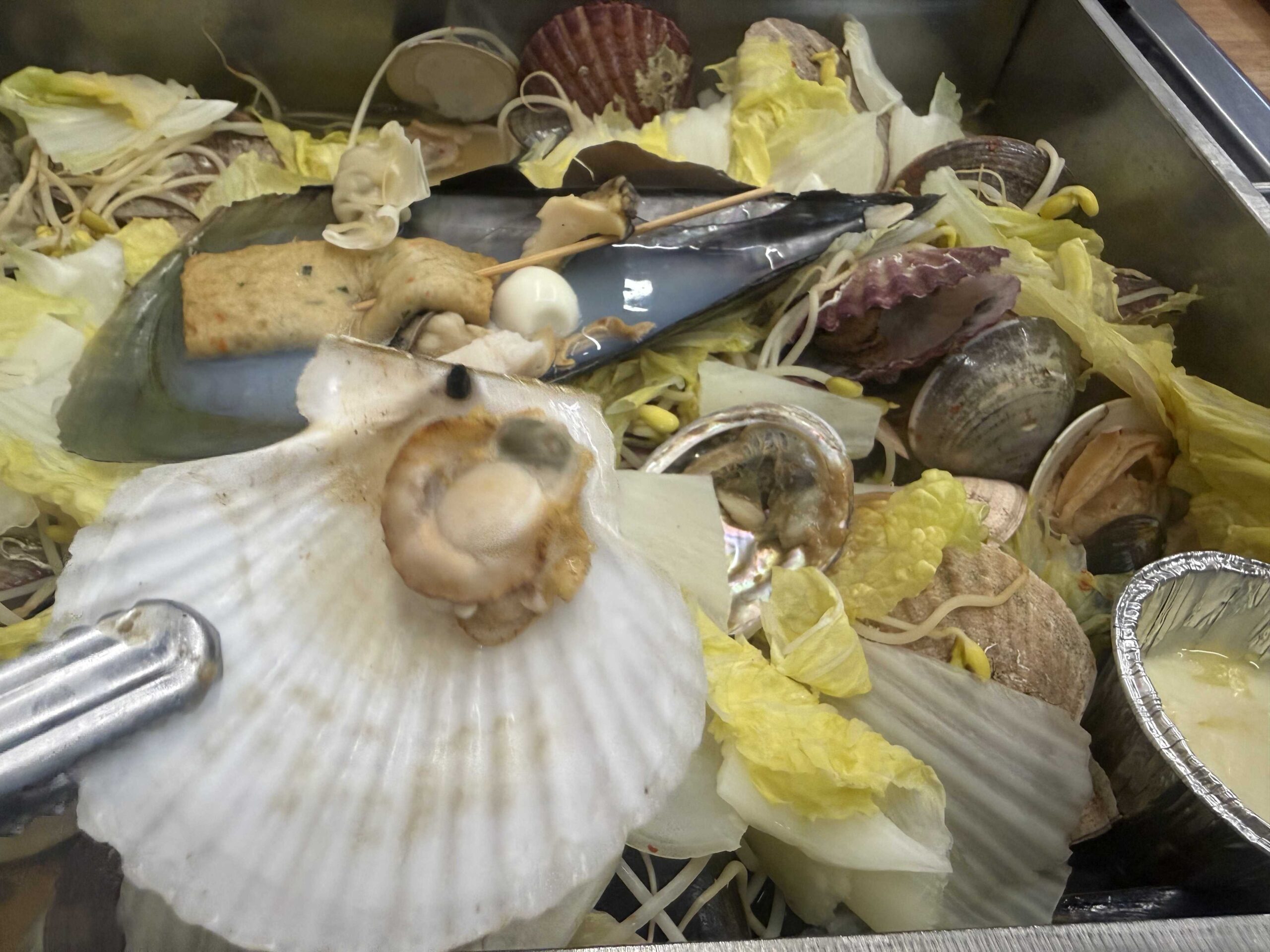 Open scallop shell with pink scallop meat at Jjimagi Jamsil Bangi seafood steamer