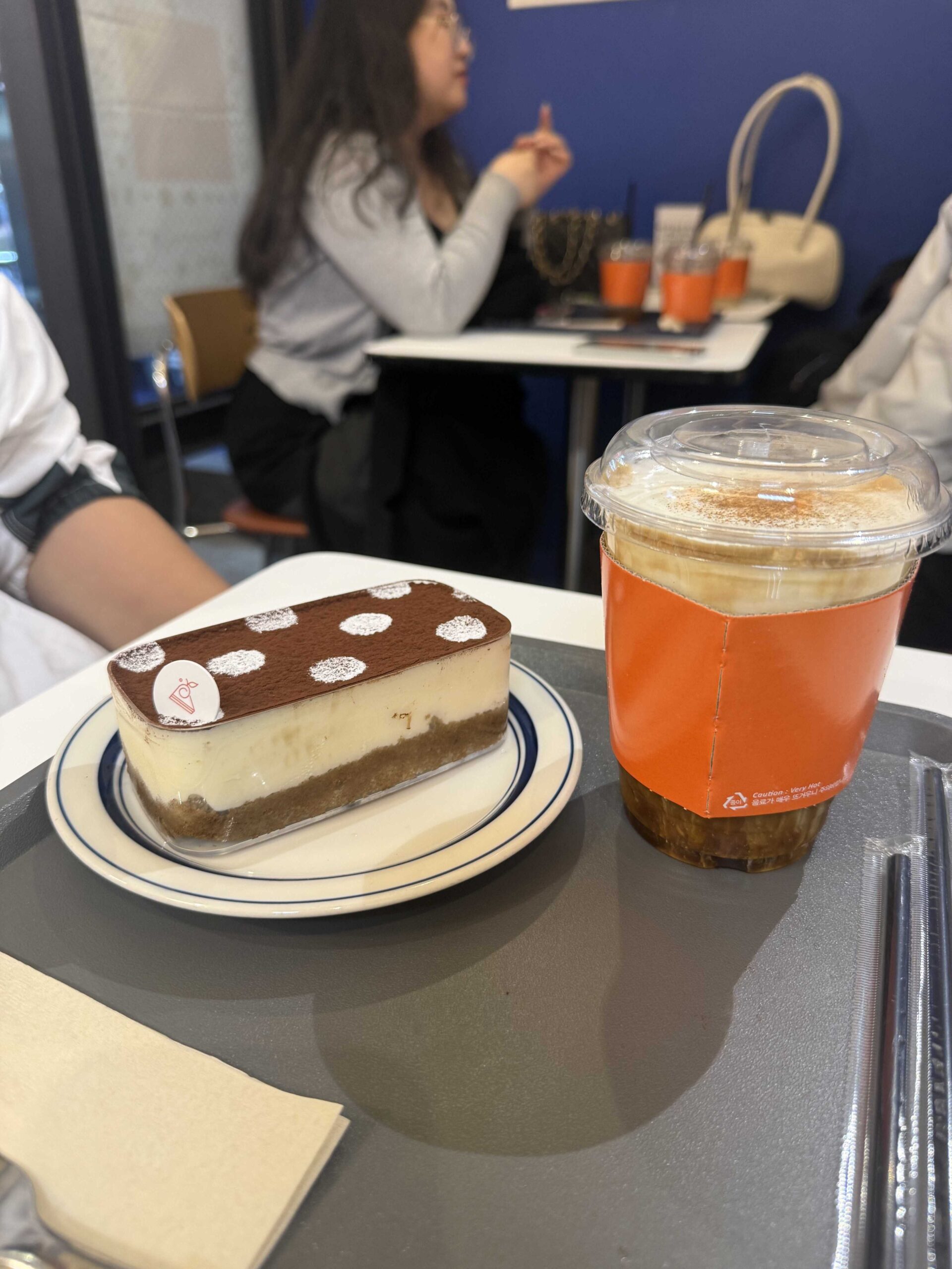 Petit Chlo Jamsil polka-dot tiramisu slice beside an iced cream latte