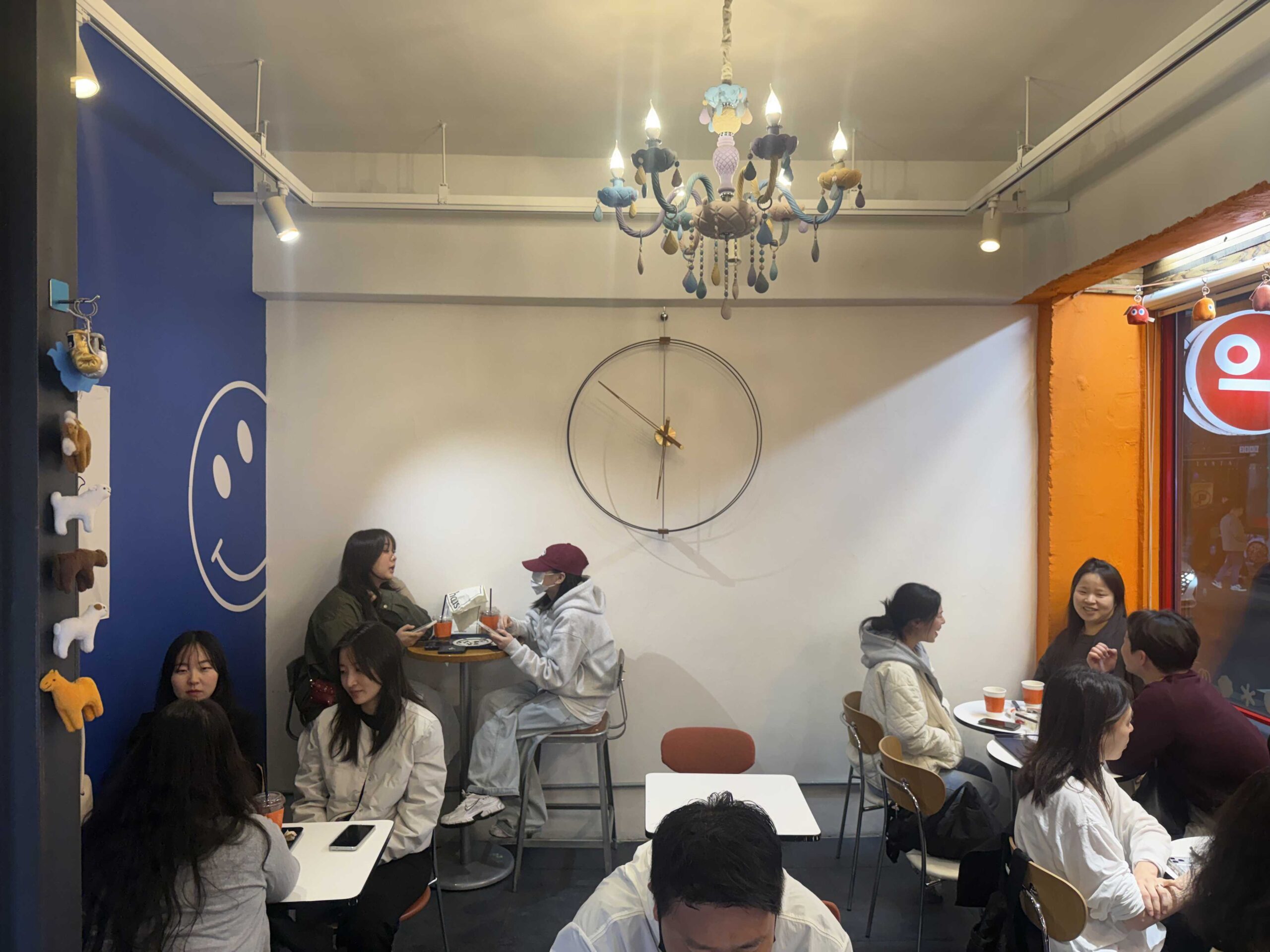 Petit Chlo Jamsil packed interior with chandelier, large clock, and customers at tables