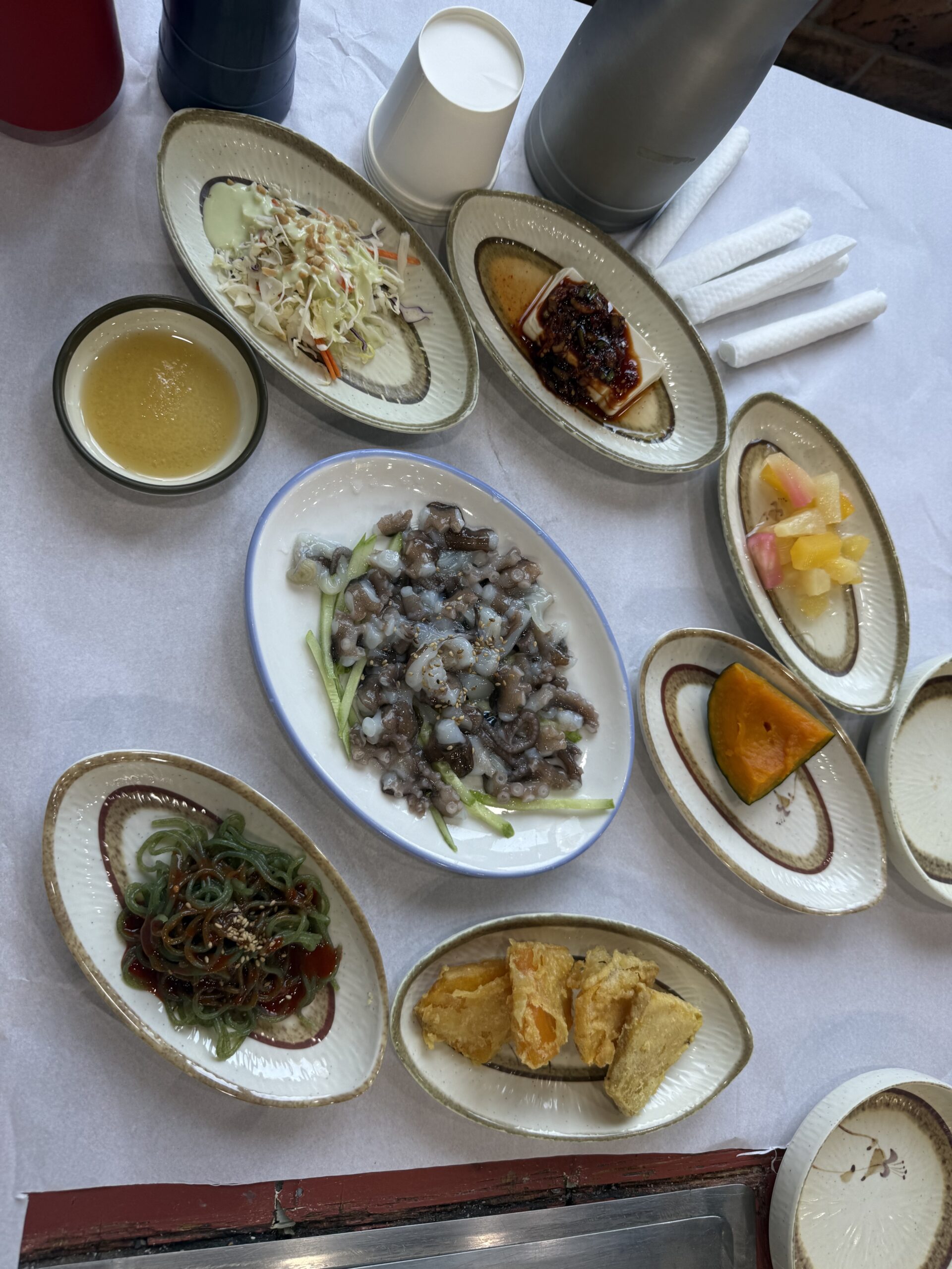 Korean banchan side dishes at Pungnyeon Hwesenta with naktji tangtangi center