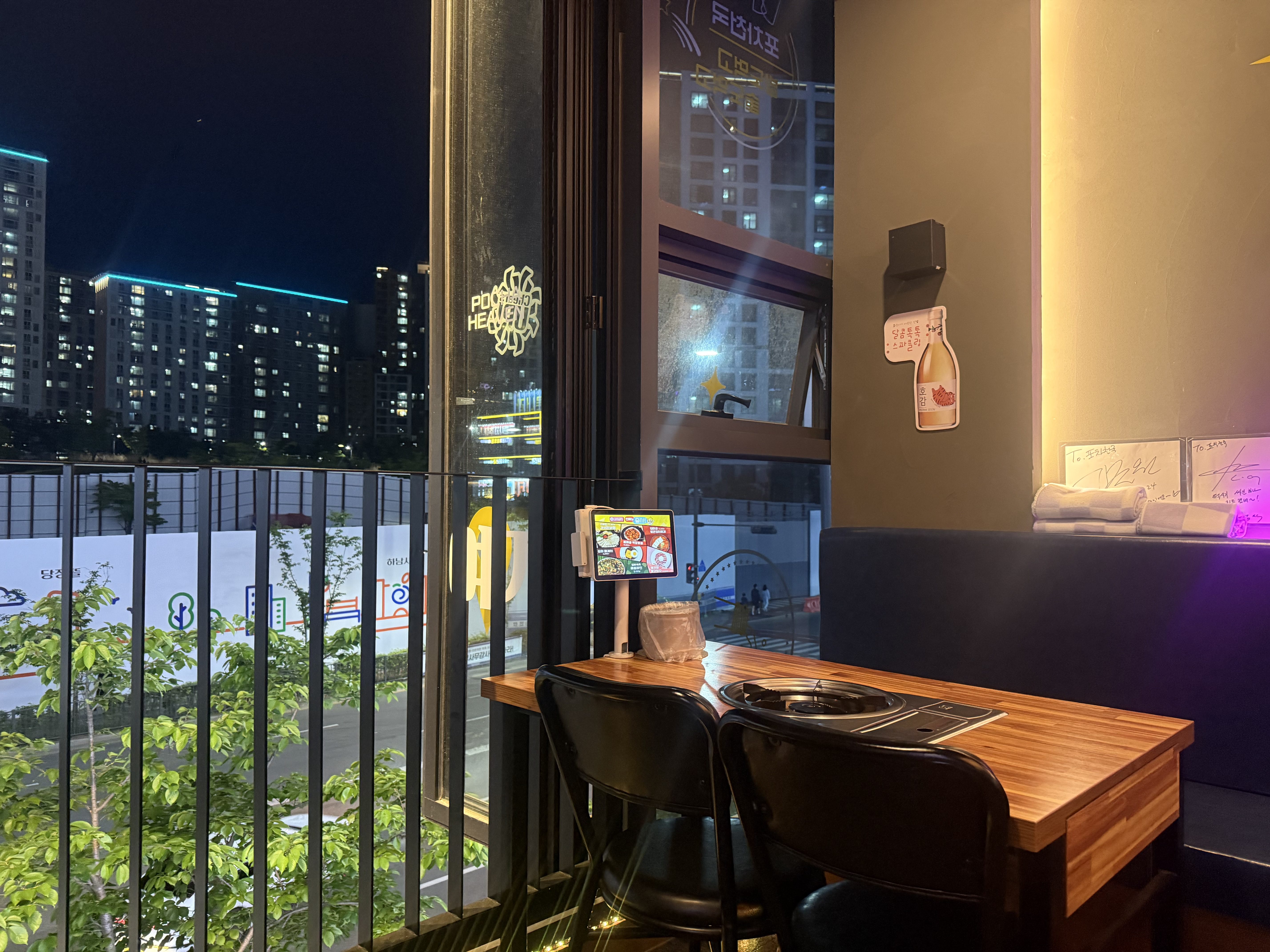 Window seat at Pocha Cheonguk Hanam overlooking Hanam city blocks at night