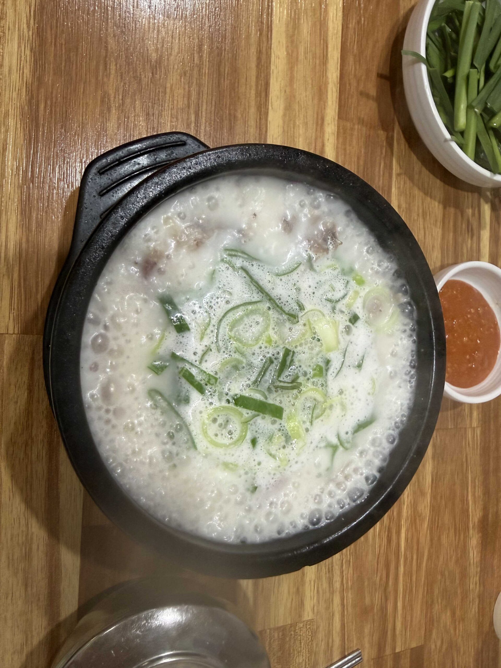 White broth baek sundae guk with chopped scallions at Dukkeobi Sundae Guk Hanam