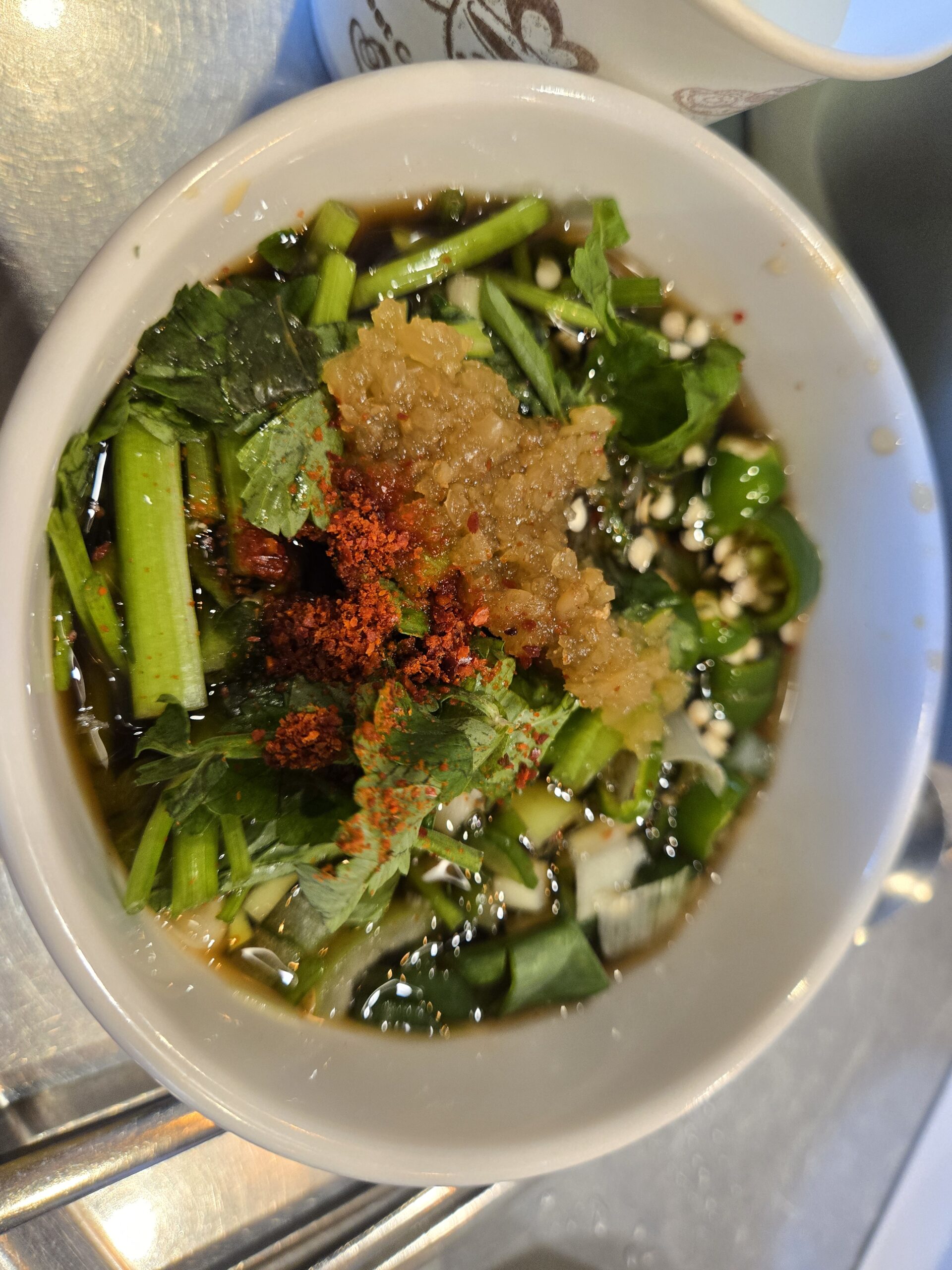 Soy chili dipping sauce with chopped chives garlic and pepper at Jinseong Hanu Gopchang