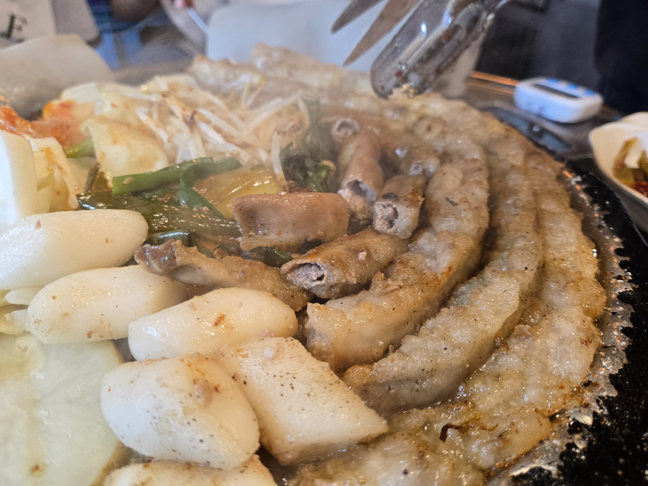 Round-shaped Korean beef gopchang cooking on hot stone plate at Jinseong Hanu Gopchang