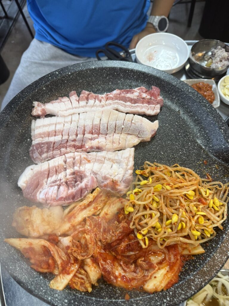Pork belly on the grill with kimchi and bean sprouts