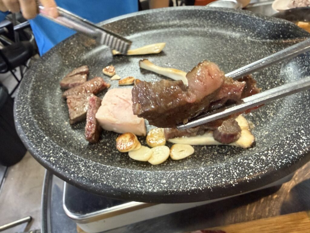 Beef pieces on the grill with garlic