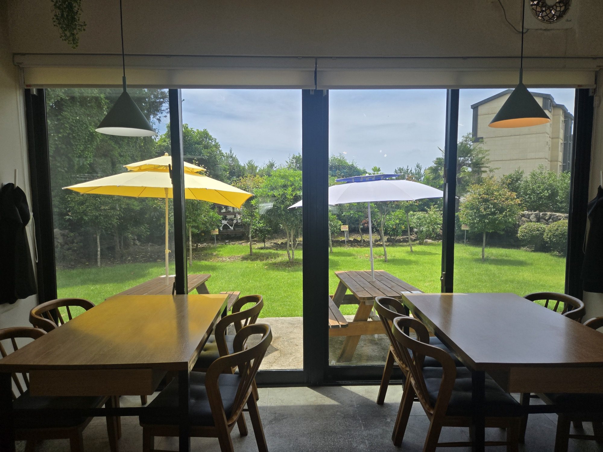 Garden view seating with umbrellas at Dajeongine Gimbap Seogwipo