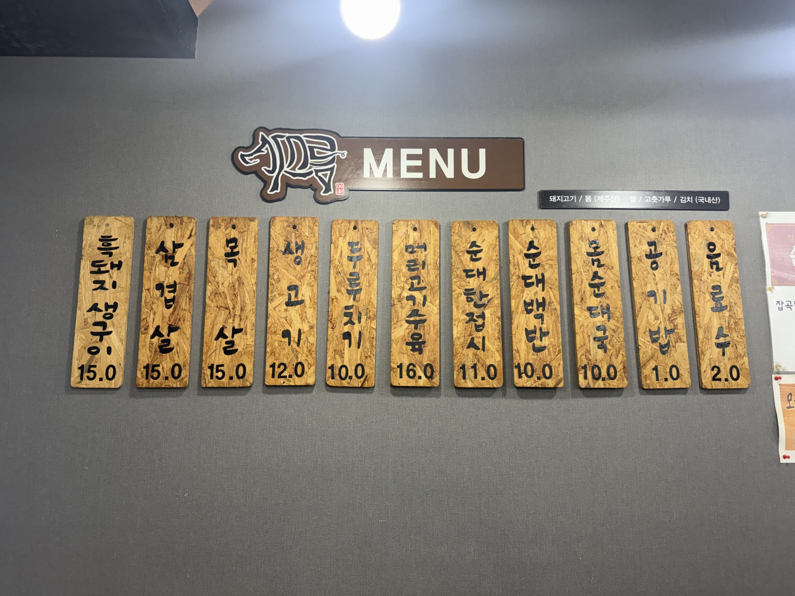 Wooden menu boards at Gaseureum Sikdang listing Jeju pork dishes