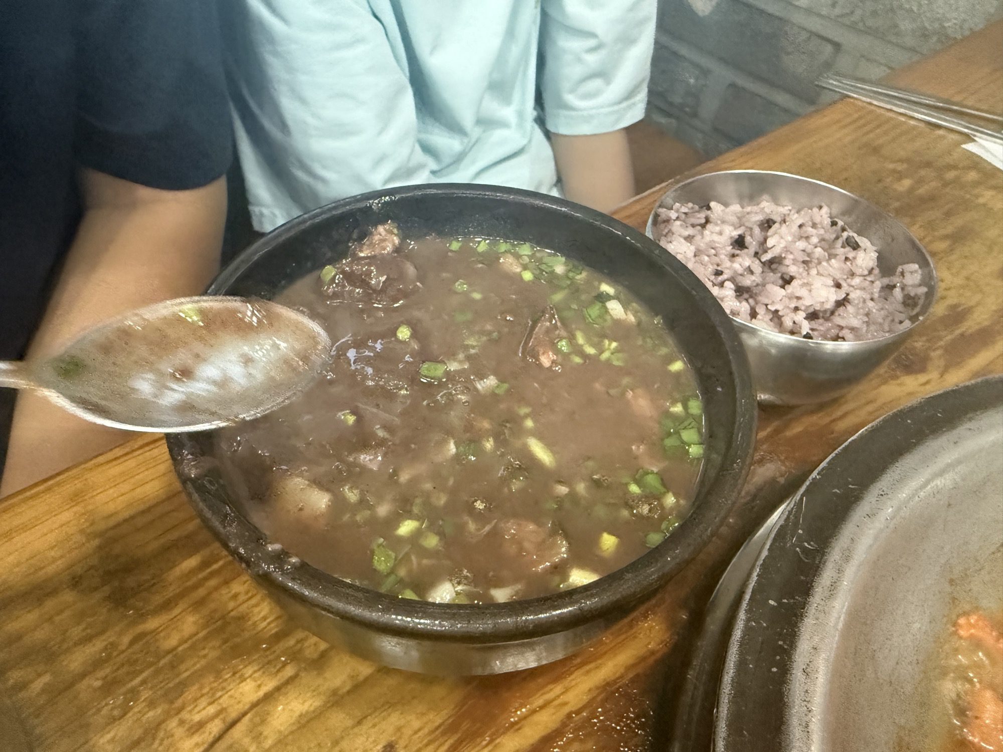 Spoon lifting broth from the blood sausage soup at Gaseureum Sikdang
