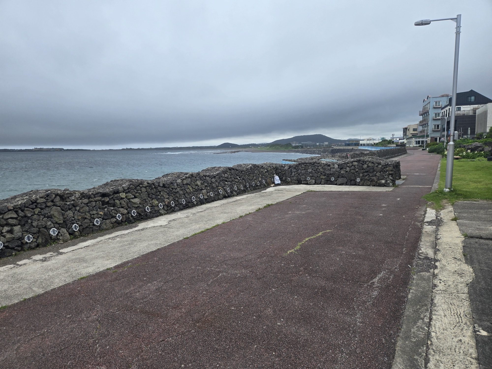 Coastal walking path and stone wall near the Seongsan black pork restaurant
