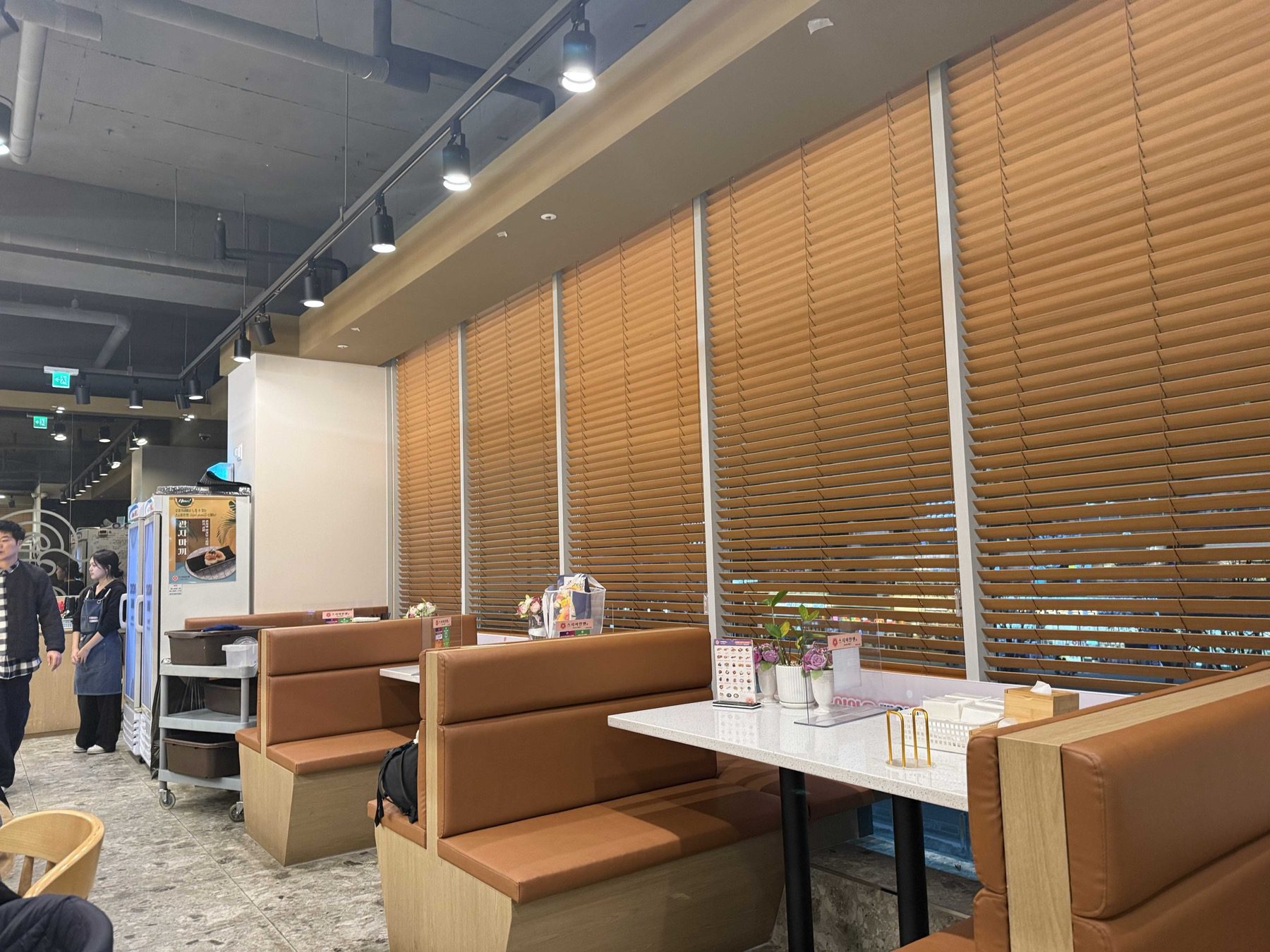 Booth seating with tan leather benches and wooden blinds at Sushi Ian Wirye