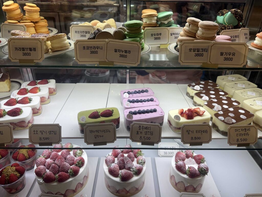 Macarons on the top shelf and cake slices below