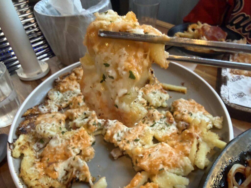 Lifting a piece of the cheese potato
