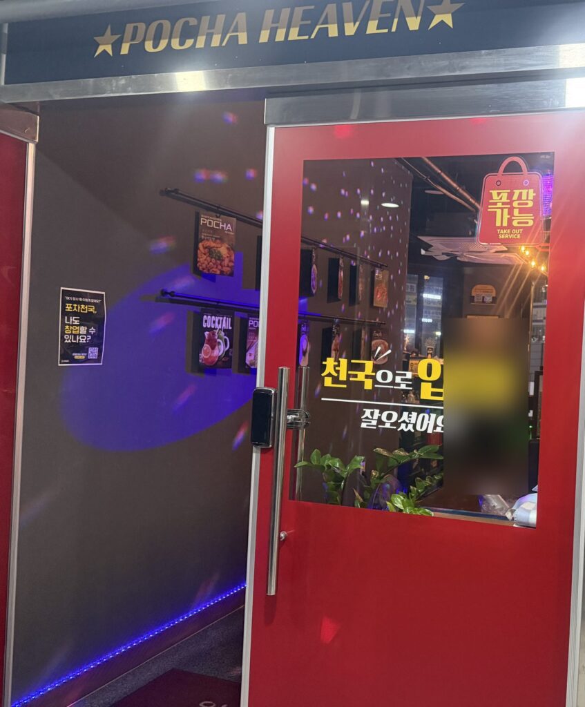 The red entrance door under the POCHA HEAVEN sign