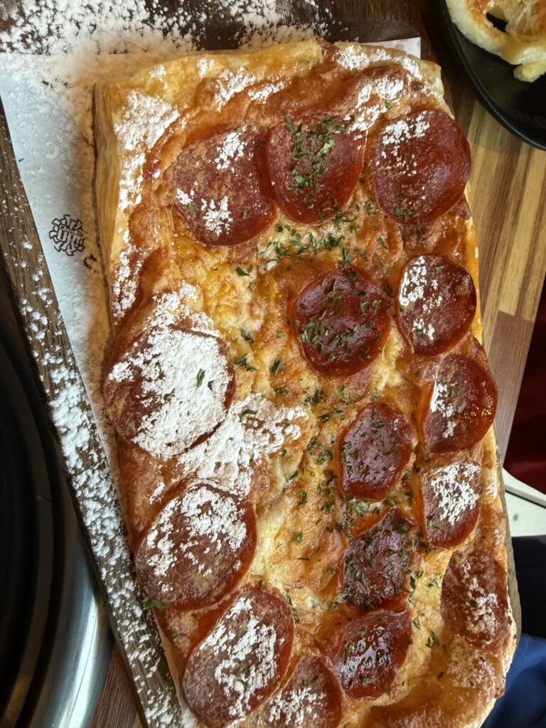 The pepperoni pastry pizza on its board