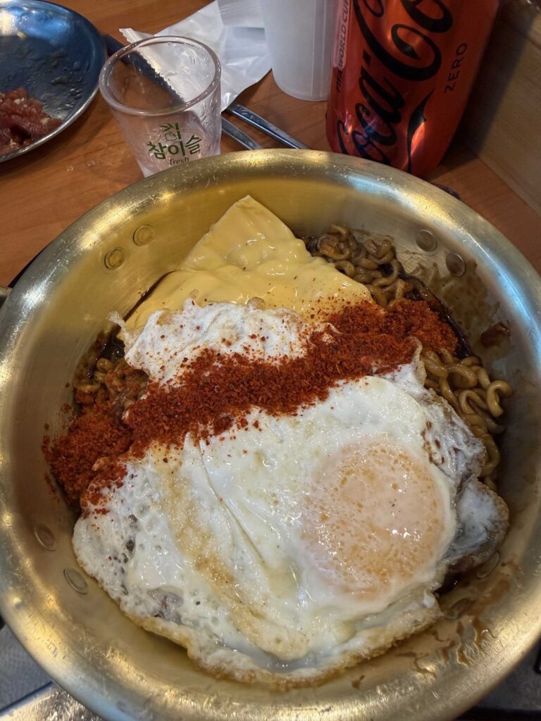 Jjagyechi with a fried egg, cheese and chili powder